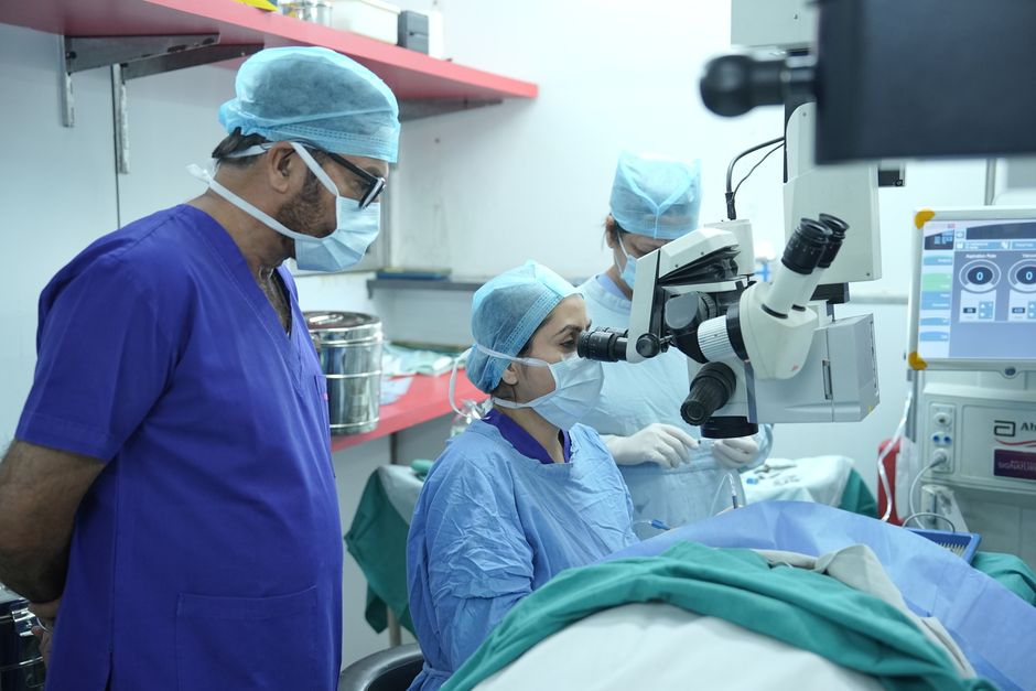 Operating microscope and surgical team performing microsurgical TESE testicular sperm extraction procedure Korea